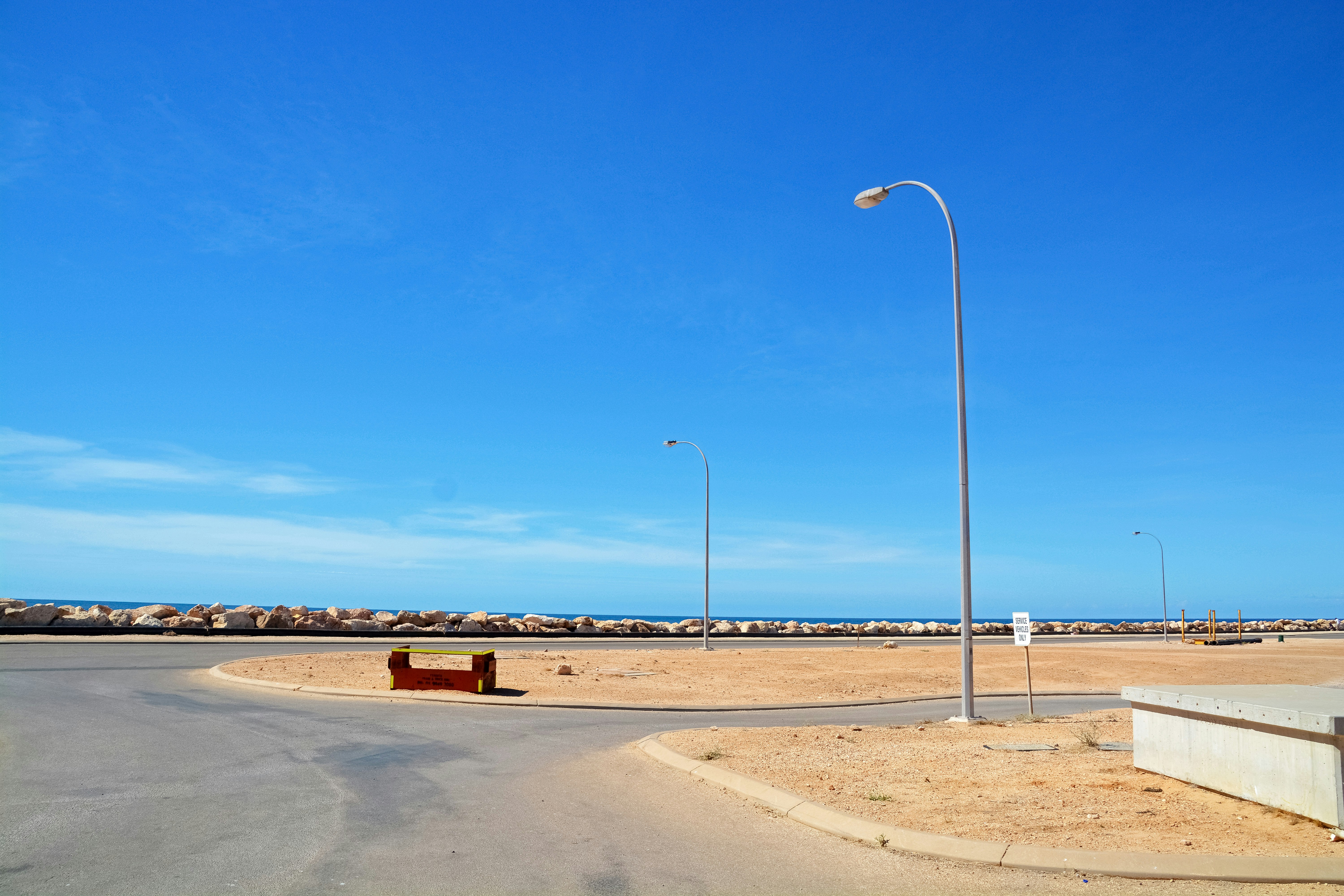 white street light on brown sand under blue sky during daytime